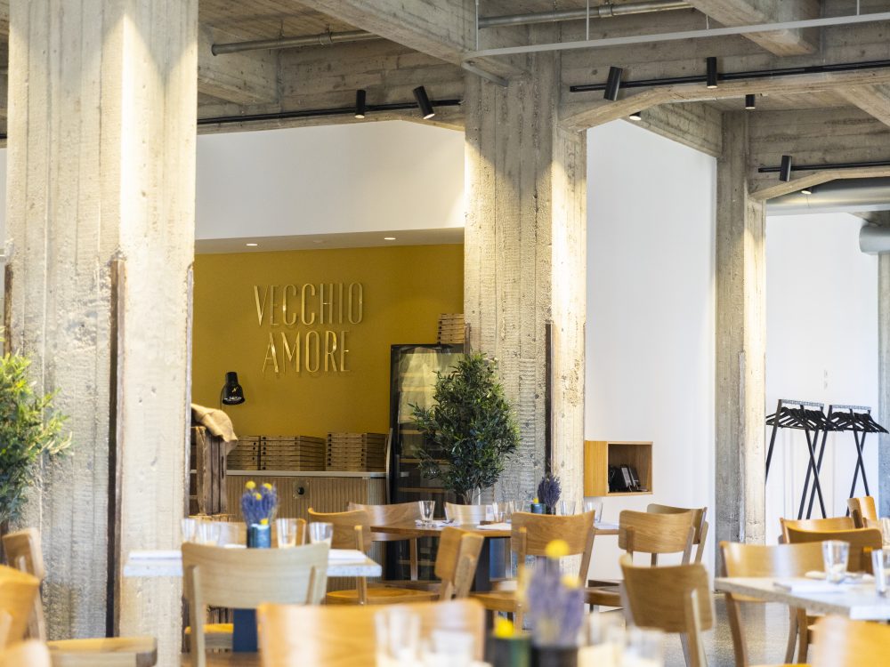 Elegantes Restaurantinterieur von Alte Liebe Catering mit Schriftzug Vecchio Amore an der Wand.