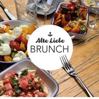 ein Holztisch, der mit Schalen von Essen vom Alte Liebe Catering bedeckt ist