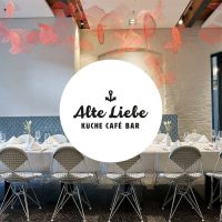 ein Tisch mit Stühlen und einem Schild, das sagt Alte Liebe Catering im Leike Küche Café Bar